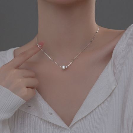 Side view of the silver pearl necklace on a model, highlighting its elegant drape.