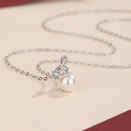 Angled shot of the pearl pendant necklace, highlighting the shine of the 925 sterling silver.