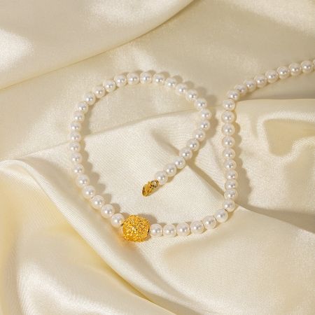 Detailed view of the pearl necklace's secure and stylish gold clasp.