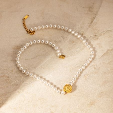 Full view of the pearl necklace with shimmering gold accents on a white background.