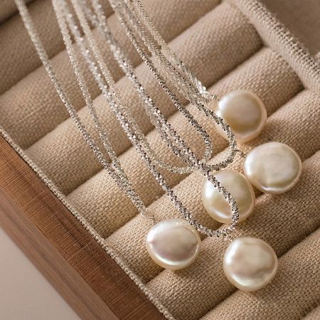 The complete set of five vintage pearl necklaces beautifully arranged in a rustic wooden box.