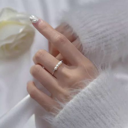 Another style from the set of five pearl rings, worn on the ring finger for an elegant look.