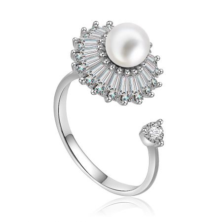 Side view of the spinning pearl ring showcasing the baguette-cut diamonds and silver metal band.