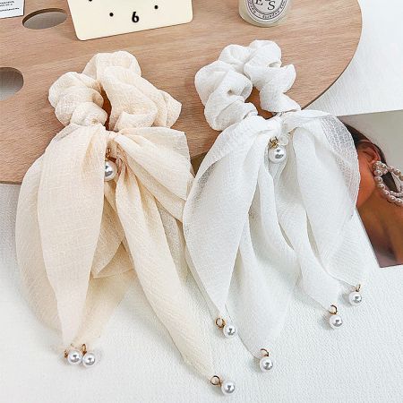 Two beautiful scrunchies with pearl details, perfect for any hairstyle.