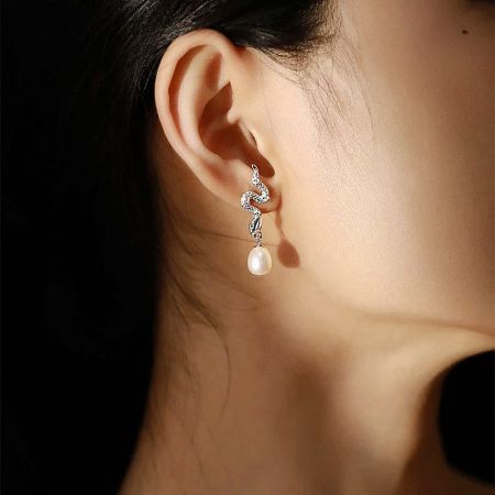 Another perspective of the pearl snake earring, emphasizing the pearl's luster.