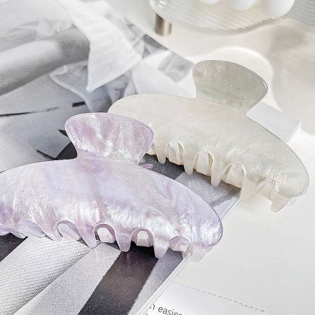 Two pearlescent acetate claw hair clips showcasing their elegant finish.