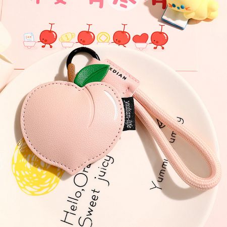 Soft pink peach-shaped PU leather keychain with a matching wrist strap.