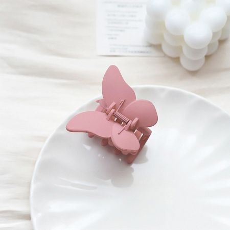 A stylish matte pink butterfly jaw clip, perfect for securing thick hair.