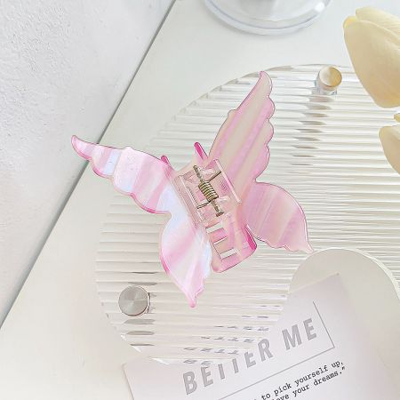 A close-up of a pink butterfly hair clip with a striped acetate pattern.