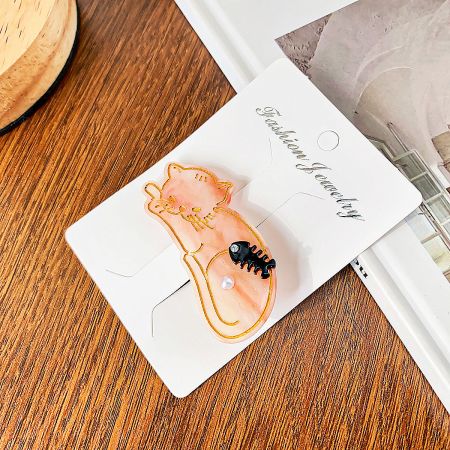 Detailed view of the pink cat-shaped hair clip, highlighting its glossy acetate finish.