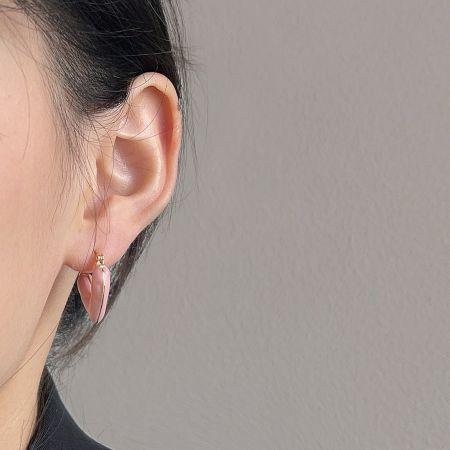 Model wearing the pink enamel heart hoop earring, showing its size and fit.