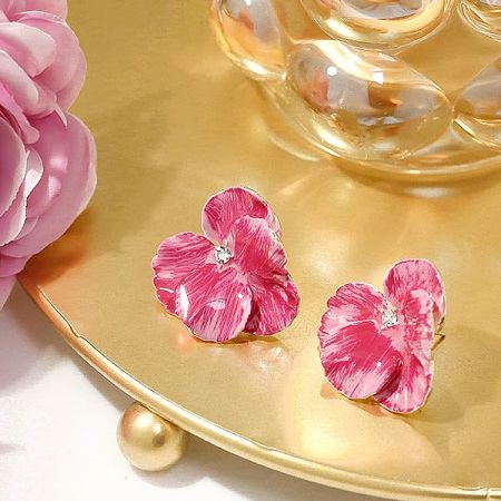 The flower earrings elegantly displayed on a decorative gold tray.