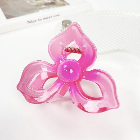 A vibrant pink plumeria flower hair clip on a white background.