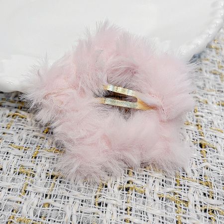 A vibrant pink plush star hair clip with its durable gold-tone snap clasp.