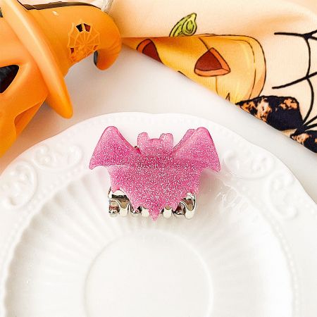 A stylish pink glittery bat-shaped hair clip for Halloween.
