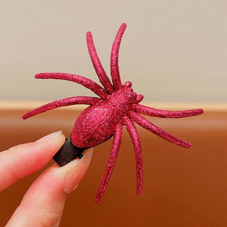 A vibrant pink glittery plastic spider hair clip.