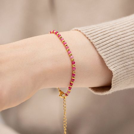 Close-up view of a pink and gold beaded bracelet, perfect for stacking.