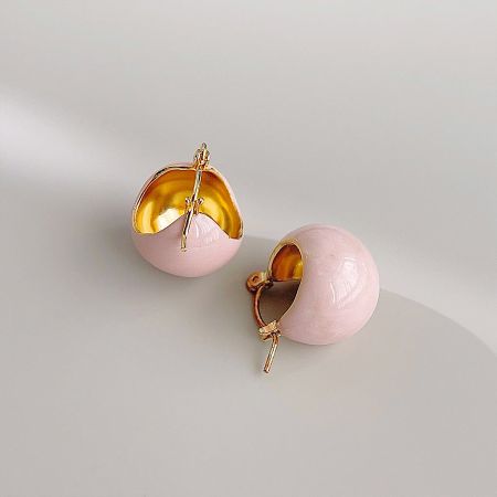 Detailed view of the pink and gold spherical earrings, highlighting the hollow gold interior.