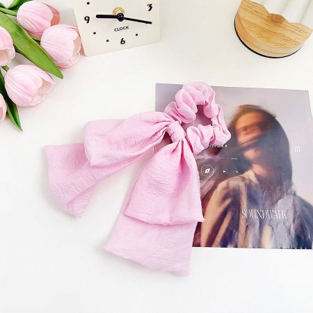 Detailed view of the soft pink fabric hairband.