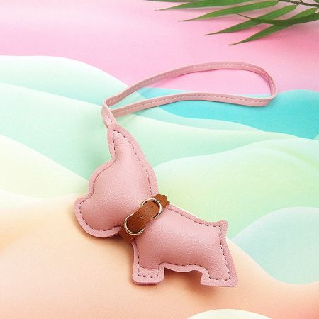 A close-up of a charming pink PU leather French Bulldog keychain with a gold attachment ring.