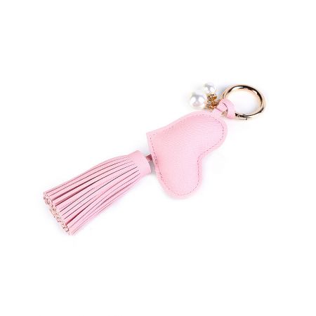 Detailed view of the pink heart-shaped PU leather keychain, featuring a soft tassel and delicate pearl accents.