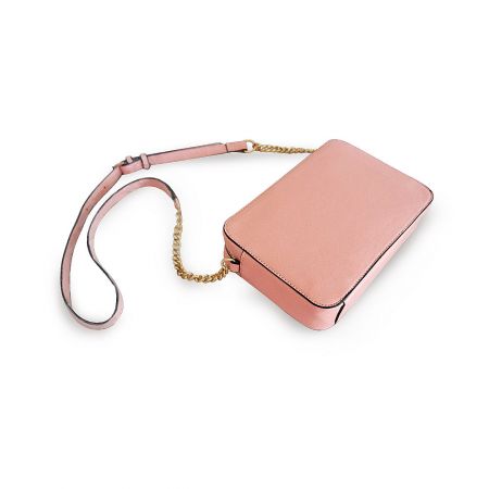 Side view of the pink leather purse highlighting the elegant gold chain strap.