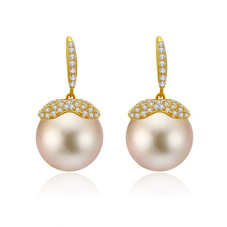 Elegant drop earrings featuring large pink pearls with diamond-encrusted gold settings and hooks.