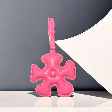 A vibrant pink puzzle piece bag charm, perfect for adding a pop of color.