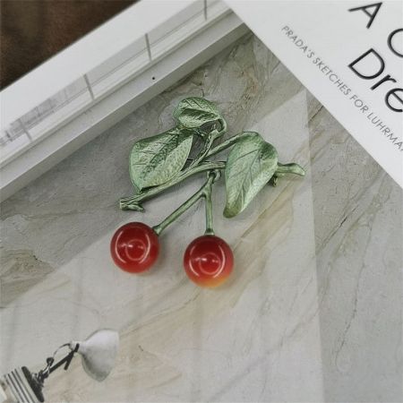 Sweet Retro Cherry Baked Paint Brooch for Women (5 pcs) - A close-up of the Sweet Retro Cherry Brooch, showing the glossy red baked-paint finish and polished gold-tone stem with green leaves, on a clean white background.
