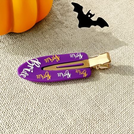 Close-up of a purple no-crease hair clip with the word 'Bride' in a gothic font.