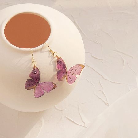 Product shot of the purple butterfly earrings against a white background.