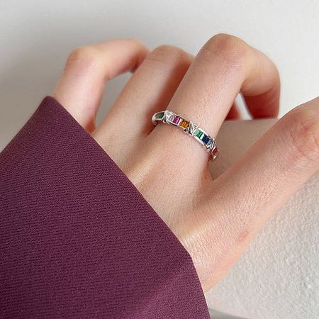 A vibrant 925 sterling silver ring with rainbow gemstones worn on a finger.