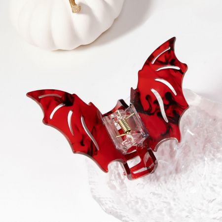 Detailed view of the vibrant red bat-shaped hair clip.