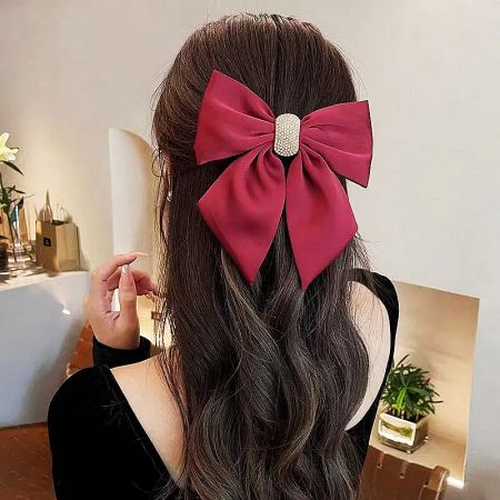 Product shot of the red bow hair clip, emphasizing its rich color and quality fabric.