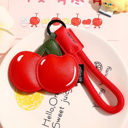 Vibrant red cherry keychain charm made from PU leather with a green leaf detail.