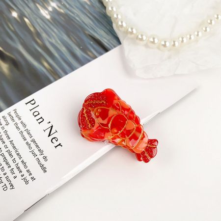 Vibrant red lobster-shaped hair clip with a glossy finish.