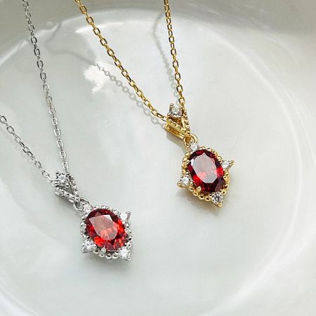 Comparison of the ruby pendant necklace in both 18K gold and sterling silver finishes.
