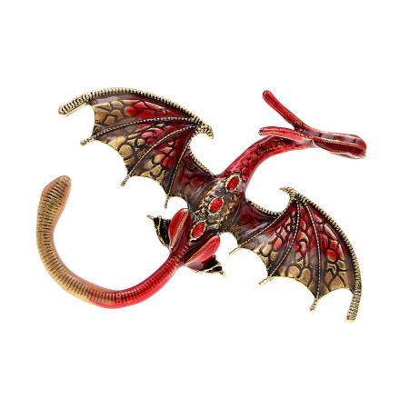 A vibrant red and gold dragon brooch, showcasing its spread wings and detailed craftsmanship.