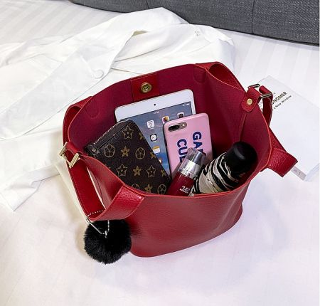 A detailed view of a red leather mini tote bag, showcasing its capacity and stylish design.