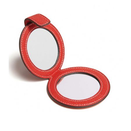A foldable double-sided compact mirror in a vibrant red leather case.