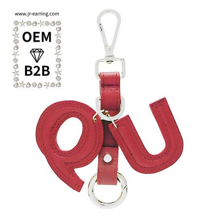 Vibrant red PU leather keychain with 'QU' initials, showcasing custom manufacturing capabilities.