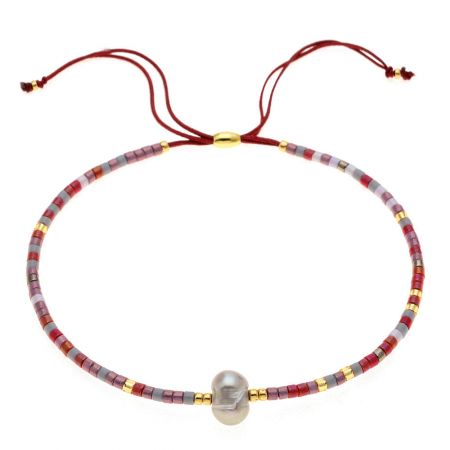Close-up of a red, pink, and gray beaded bracelet with a central pearl and adjustable cord.