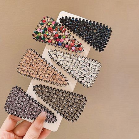 An assortment of colorful rhinestone triangle hair clips displayed on a white surface.