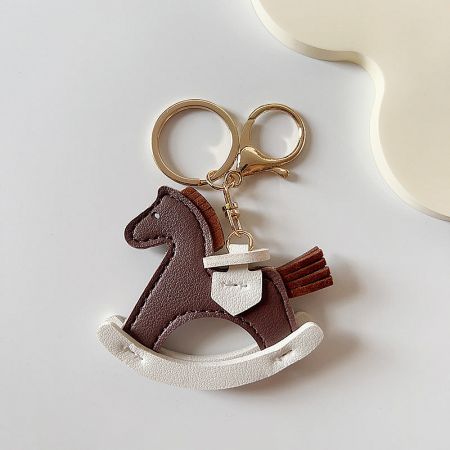 Close-up of the coffee-colored PU leather pony keychain with gold metal ring.
