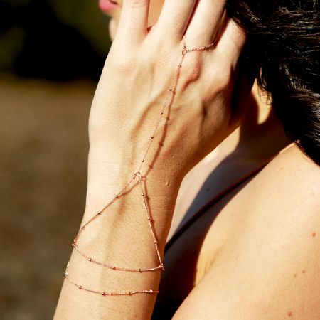 A model wearing the elegant gold-plated bead chain slave finger bracelet to showcase its fit and style.