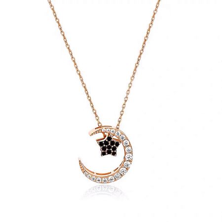 Rose gold version of the necklace, featuring a crescent moon and star pendant with clear and black stones.