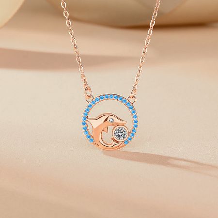 Elegant rose gold dolphin pendant necklace, showcasing the warm tone and sparkling blue gemstones.