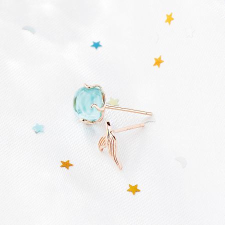 Rose gold variant of the mermaid fishtail stud earring with a light blue gemstone.