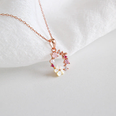 The rose gold floral necklace displayed with pink crystal and pearl accents, perfect for wholesale gift sets.