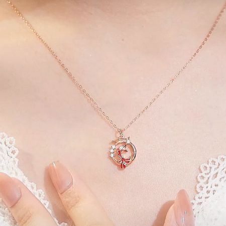 A rose gold heart-shaped pendant necklace with a red and white design, part of the charm necklace collection.